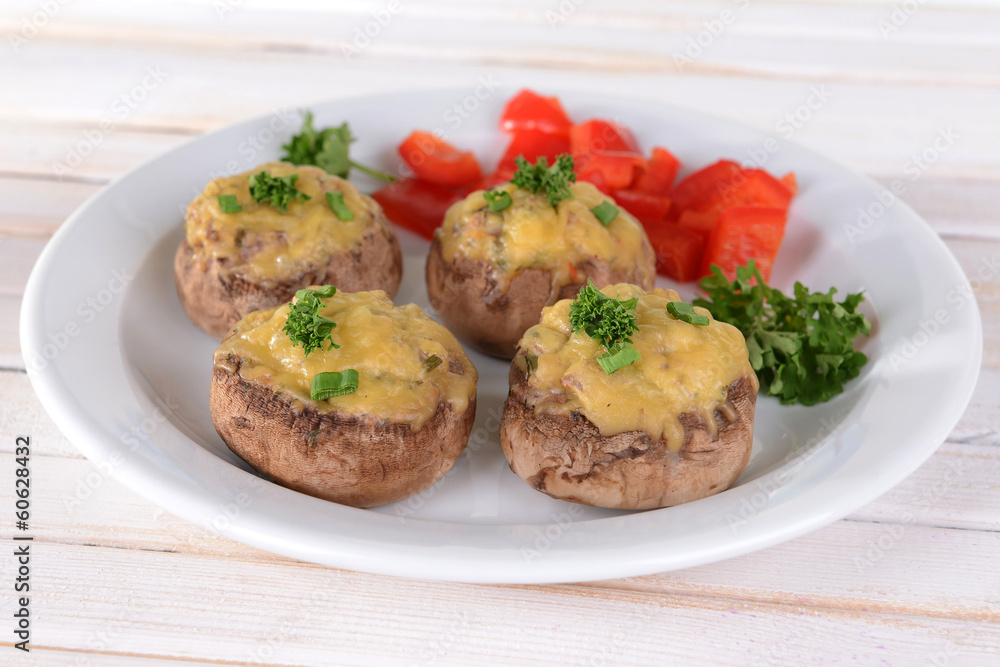Stuffed mushrooms on plate on table on light background Stuffed mushrooms on plate on table on light background