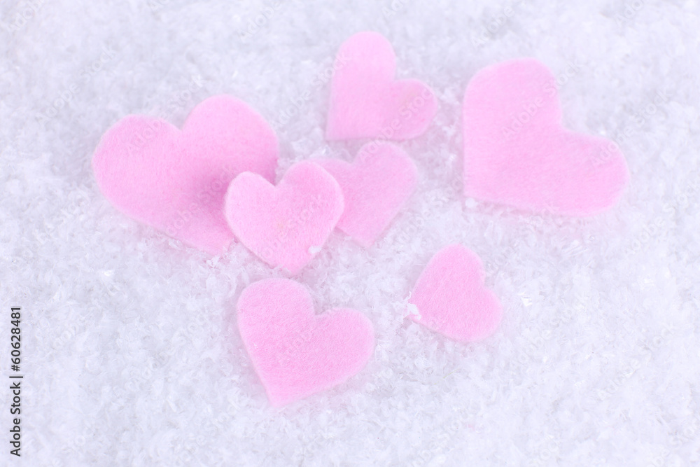 Little felt hearts on snowy background Little felt hearts on snowy background