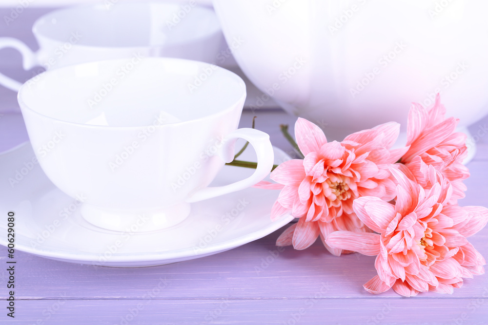 Pink chrysanthemums with tea service on wooden table Pink chrysanthemums with tea service on wooden table
