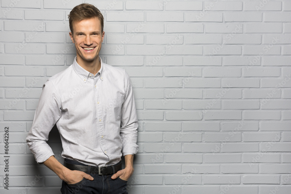 Portrait of Handsome smiling man, isolated over a brick wall Portrait of Handsome smiling man, isolated over a brick wall