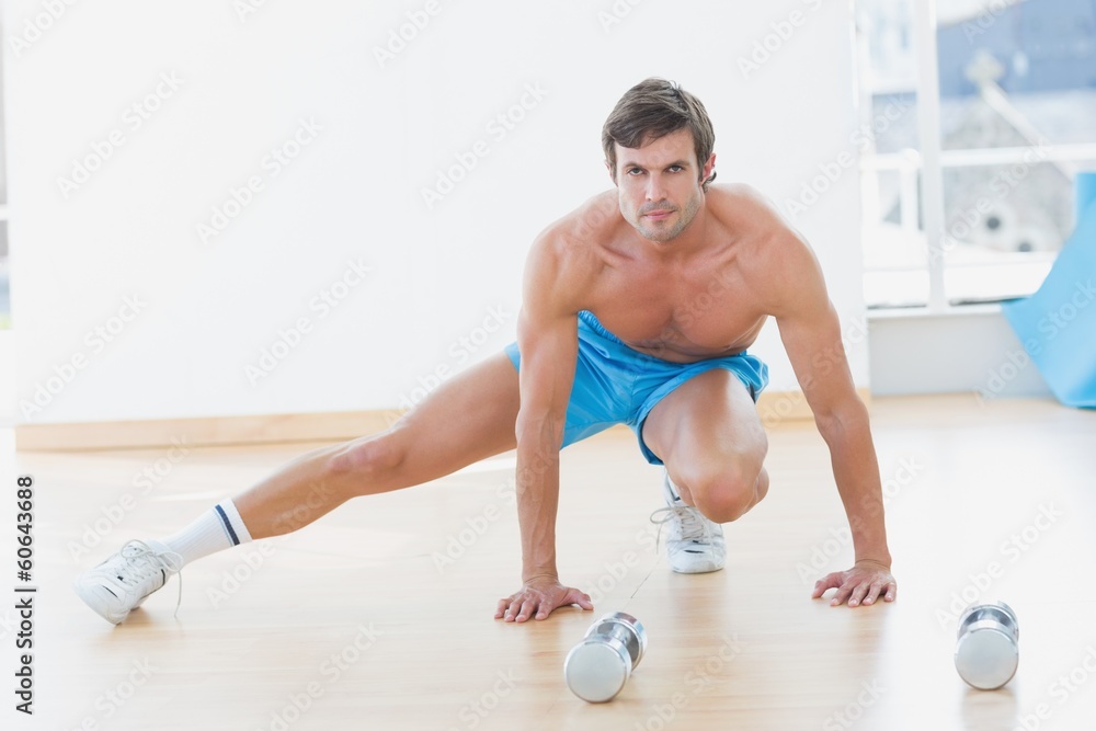 Sporty shirtless man exercising in fitness studio Sporty shirtless man exercising in fitness studio