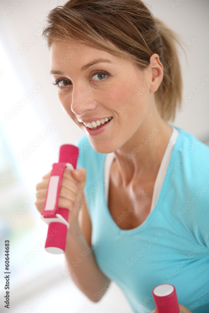 Woman in gym exercising with dumbbells Woman in gym exercising with dumbbells