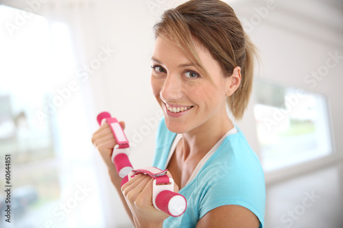 Woman in gym exercising with dumbbells