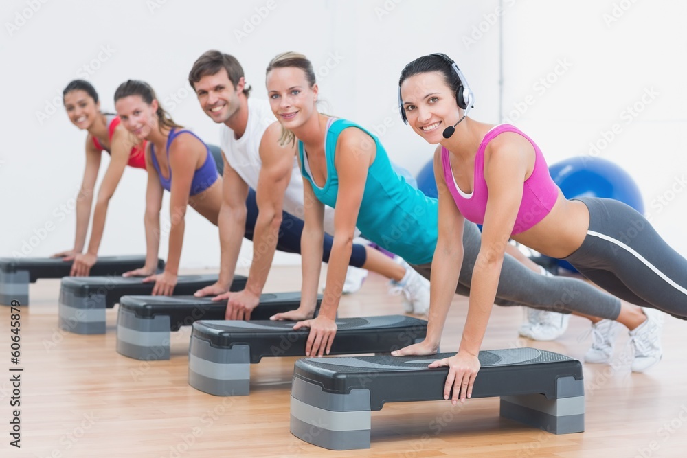Fitness class doing step aerobics exercise Fitness class doing step aerobics exercise
