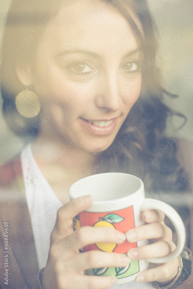 beautiful woman with cup facing through window beautiful woman with cup facing through window