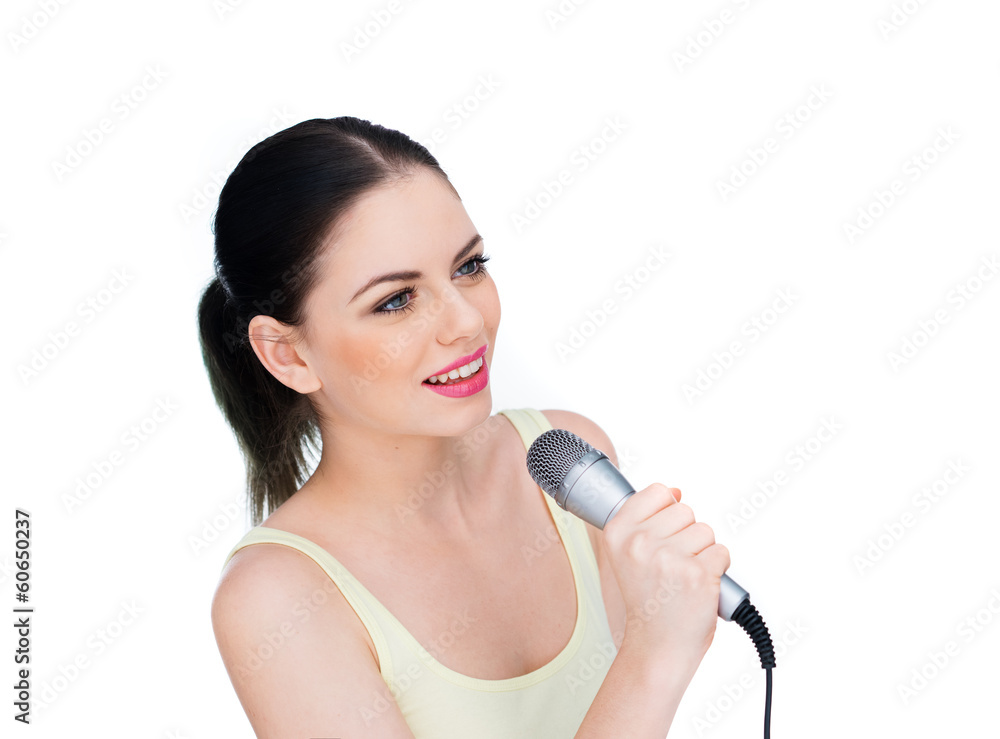 Naklejka premium Beautiful young woman singing into a microphone