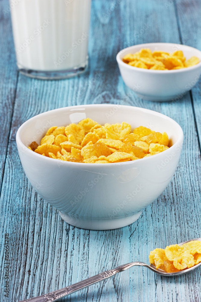 Corn flakes with raisin and milk in a ceramic cup Corn flakes with raisin and milk in a ceramic cup