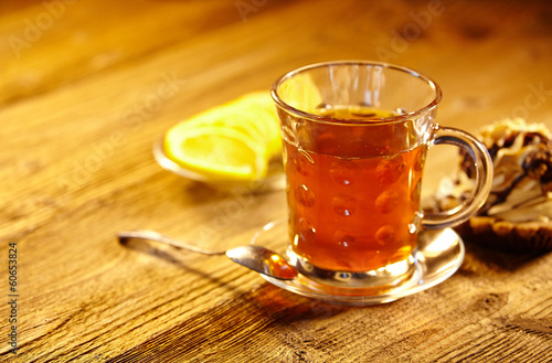 Glass of hot tea on rustic wooden table.