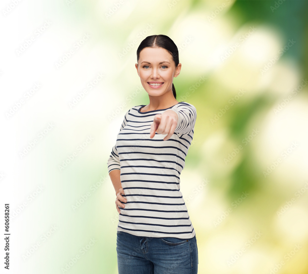 smiling girl in casual clother pointing at you smiling girl in casual clother pointing at you