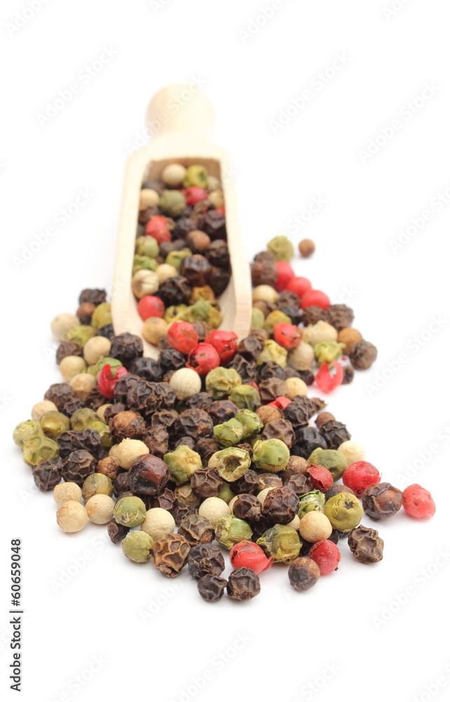 Colored pepper on a wooden spoon isolated on white background Colored pepper on a wooden spoon isolated on white background