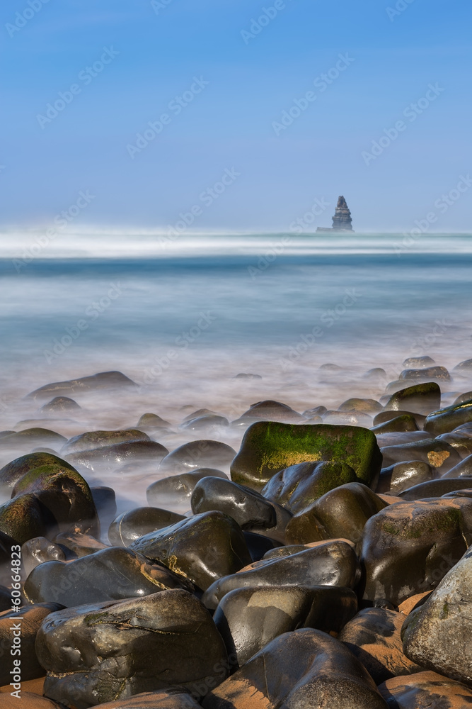 Sea stones in foreground in landscape of the sea. Aljezur.