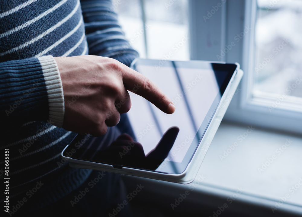 The man uses a tablet PC. Modern gadget in hand. The man uses a tablet PC. Modern gadget in hand.