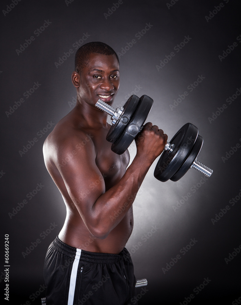 Young African Man Exercising With Dumbbells Young African Man Exercising With Dumbbells