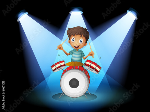 A young drummer in the middle of the stage