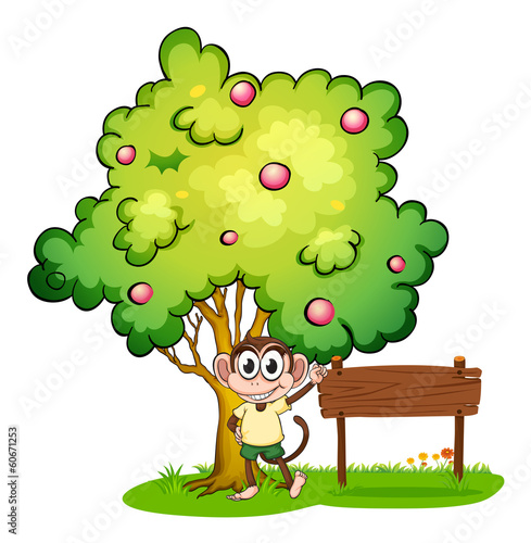 A monkey under the tree beside the empty wooden signboard