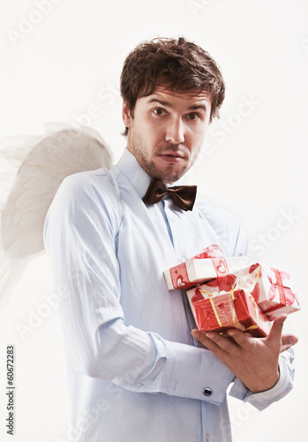Handsome young man as cupid angel with presents