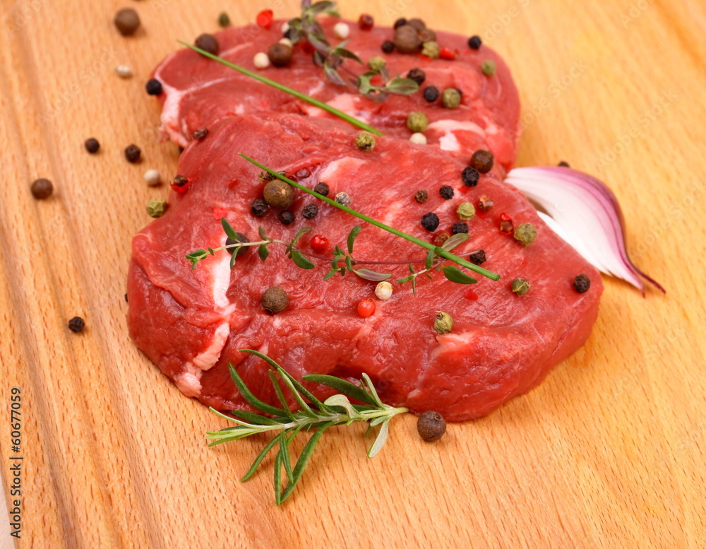 Two juicy beef steak with spices and onion