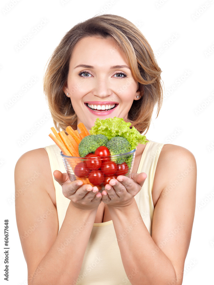 Portrait of a young smiling woman with a plate of vegetables. Portrait of a young smiling woman with a plate of vegetables.