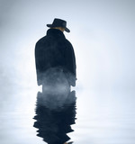person wearing trench coat and standing in water