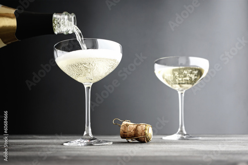 Champagne being filled in Coupe Glasses photo