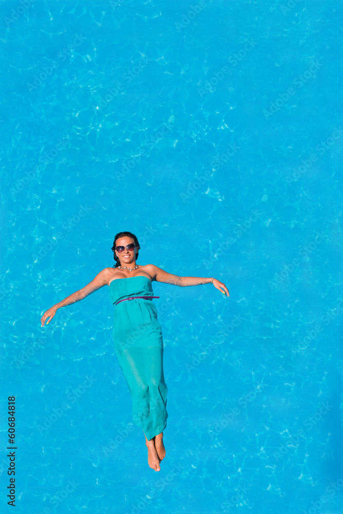 Woman floating above pool water