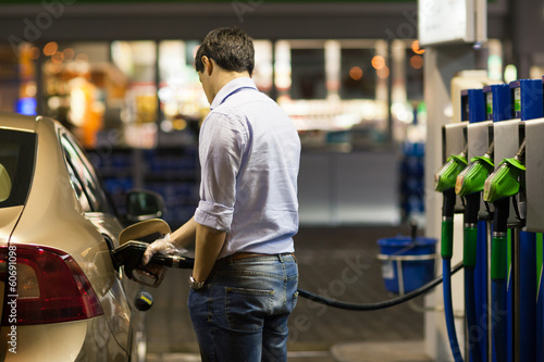 Fotografie Young man fueling his car at the gas station