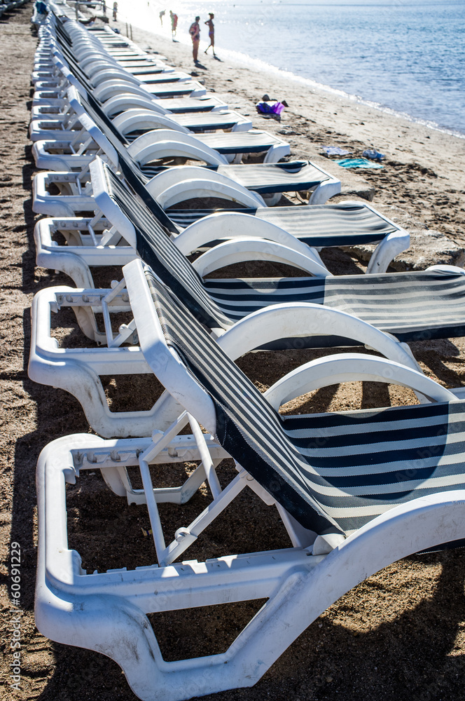 Row of empty deckchairs at seaside