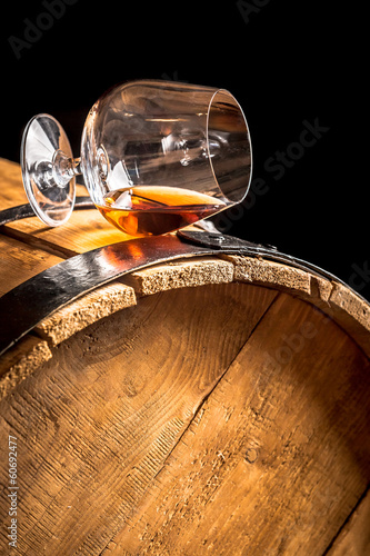 Cognac in glass on old vintage barrel