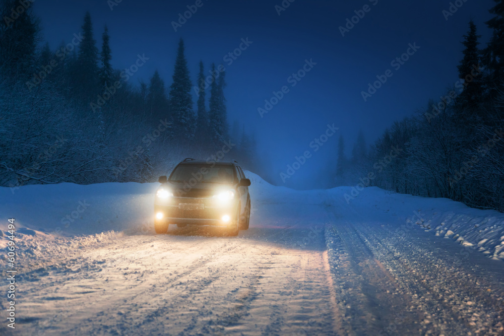 Obraz premium Car lights in winter Russian forest
