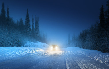 Car lights in winter Russian forest