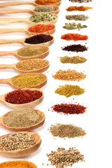 Fototapete Gewürze Assortment of spices in wooden spoons, isolated on white  © Africa Studio