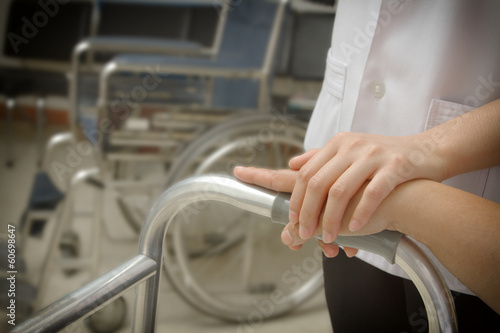 Doctor holding patient 's hand in a walker