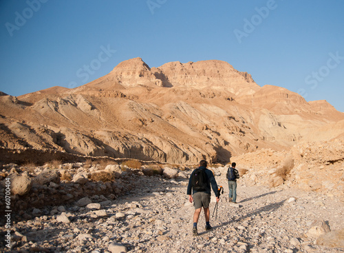 Tourists hiking in dead sea mountains