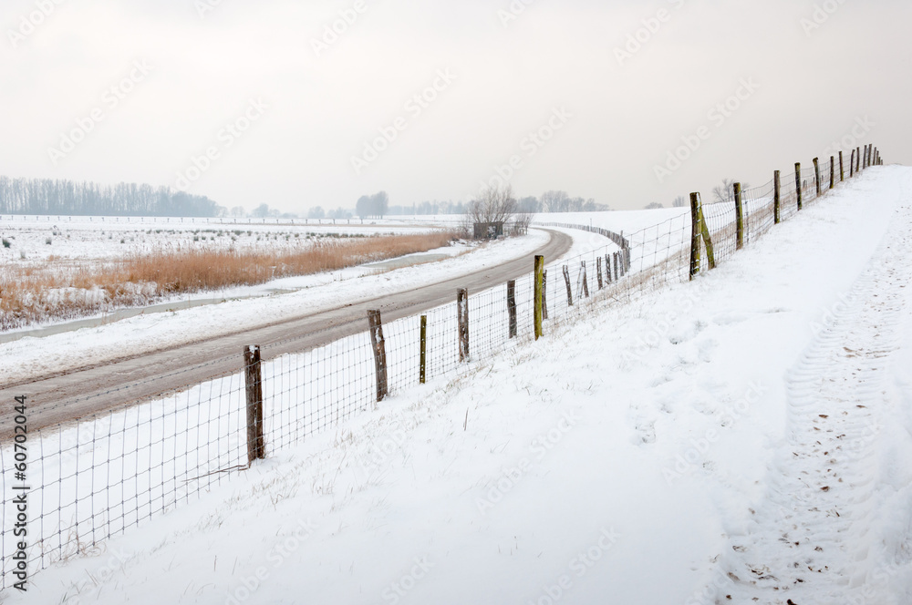 Curved country road and fences in wintertime Curved country road and fences in wintertime