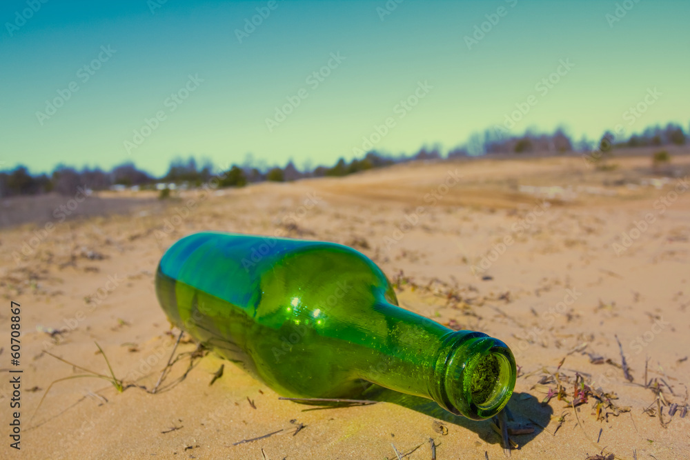 green bottle on a sand