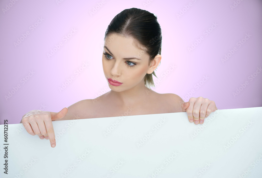 Beautiful woman pointing to a blank sign Beautiful woman pointing to a blank sign