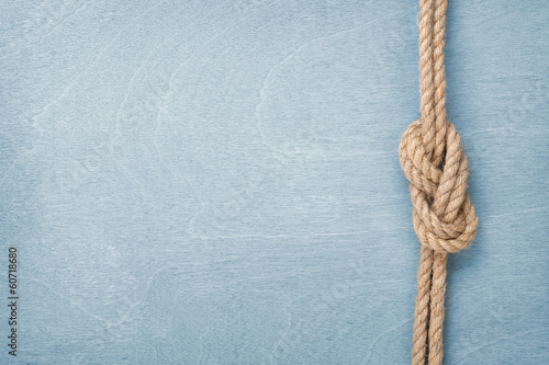 Ship rope knot on wooden texture background