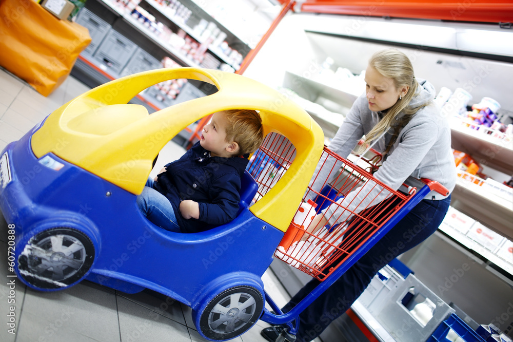 Young boy in a child friendly supermarket trolley