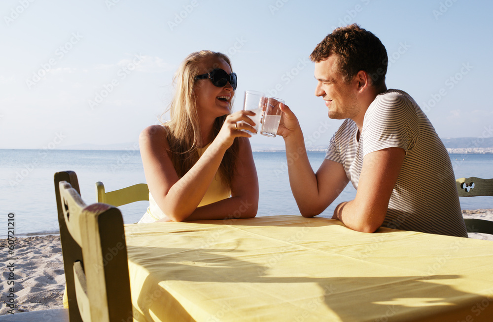 Young couple enjoying drinks at the seaside Young couple enjoying drinks at the seaside