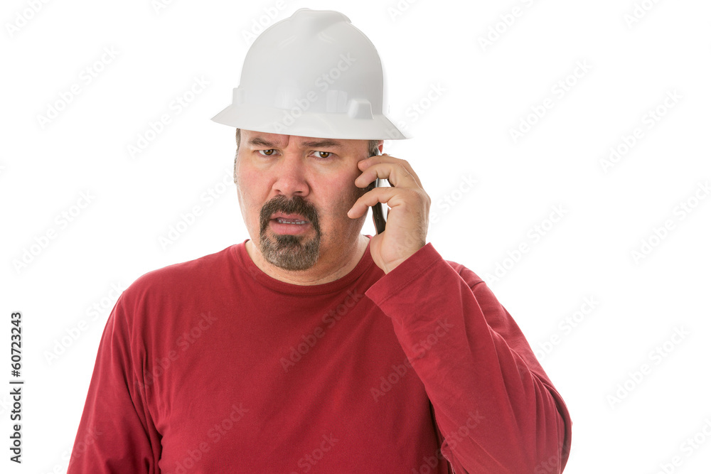Workman looking confused talking on a mobile Workman looking confused talking on a mobile