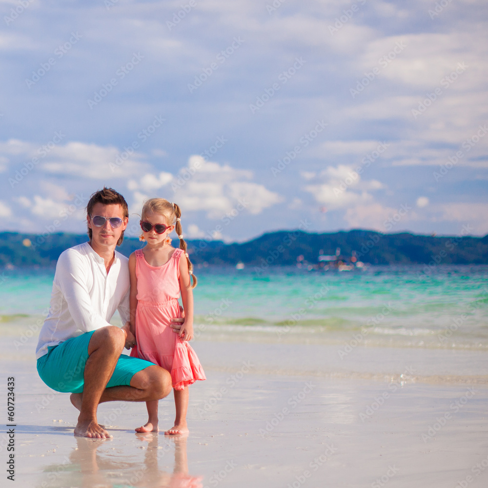 Adorable little girl and young dad on white sandy beach