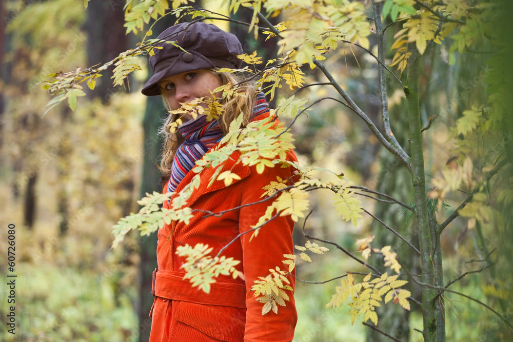 Girl in orange coat and with orange umbrella in the autumn fore Girl in orange coat and with orange umbrella in the autumn fore