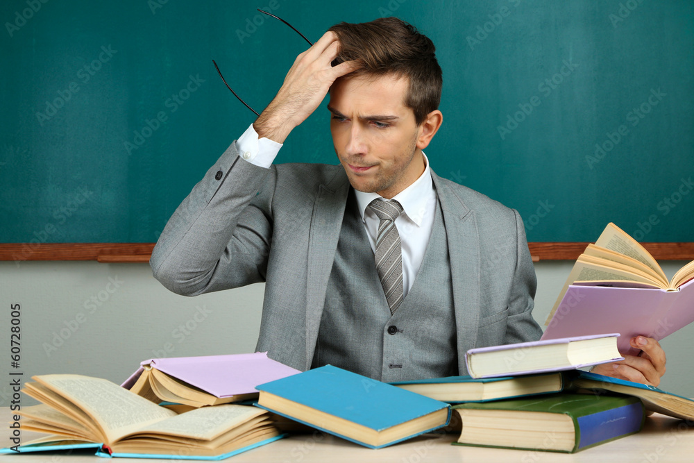 Young teacher sitting in school classroom Young teacher sitting in school classroom