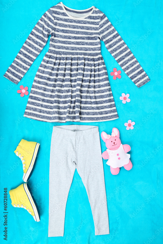 Obraz premium Beautiful clothes for little girl on blue background
