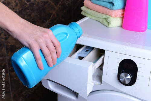 Fotografija Female hands poured powder in washing machine close-up