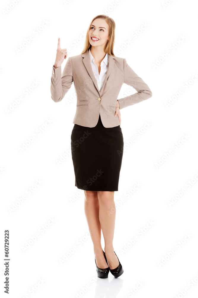 Beautiful caucasian business woman is pointing up. Beautiful caucasian business woman is pointing up.