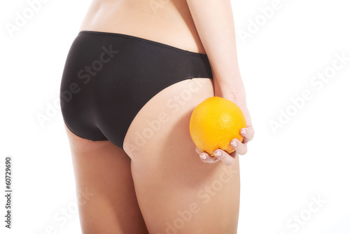 Beautiful slim and supple female buttocks with orange.