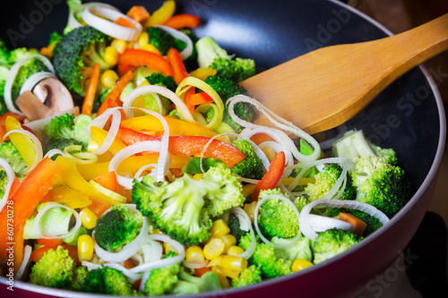 Fényképezés frying vegetables in pan with spatula