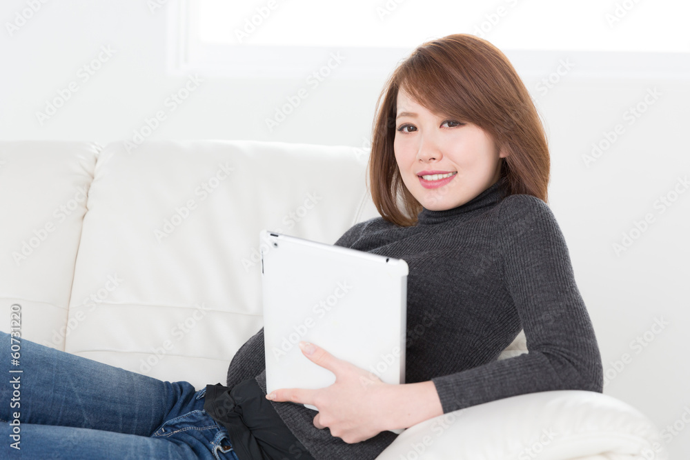 ソファでタブレットを見る女性 ソファでタブレットを見る女性