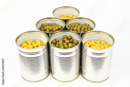 The tins with peas, corn on the white background